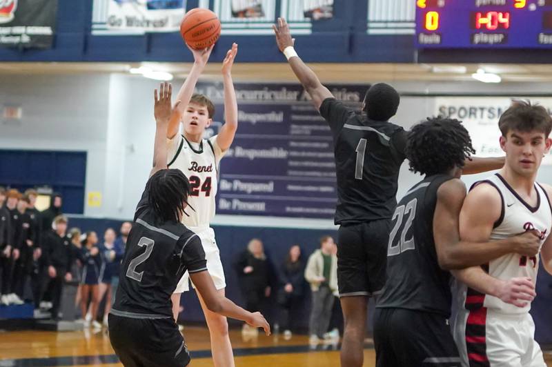 Benet’s Daniel Pauliukonis (24) shoots a three pointer over Oswego East's Mason Lockett IV (2) and Andrew Wiggins (1) during a Class 4A Oswego East regional final basketball game at Oswego East High School on Friday, Feb 23, 2024.