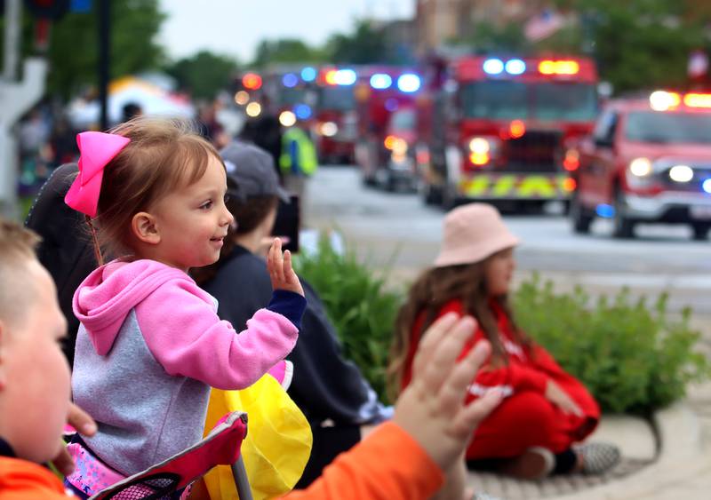 Briella Dobner, 2, of Harvard waves to first responders during the Harvard Milk Days parade Saturday, June 4, 2022, in Harvard.