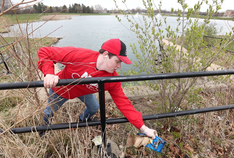 Matthew Outzen, a Northern Illinois University senior from Fulton and a member of NIU Cares, picks up garbage Friday, April 29, 2022, on campus around the West Lagoon. NIU Cares, with the help of the Trash Squirrels, was taking part in a community cleanup event, going to several locations in DeKalb to pick up litter.