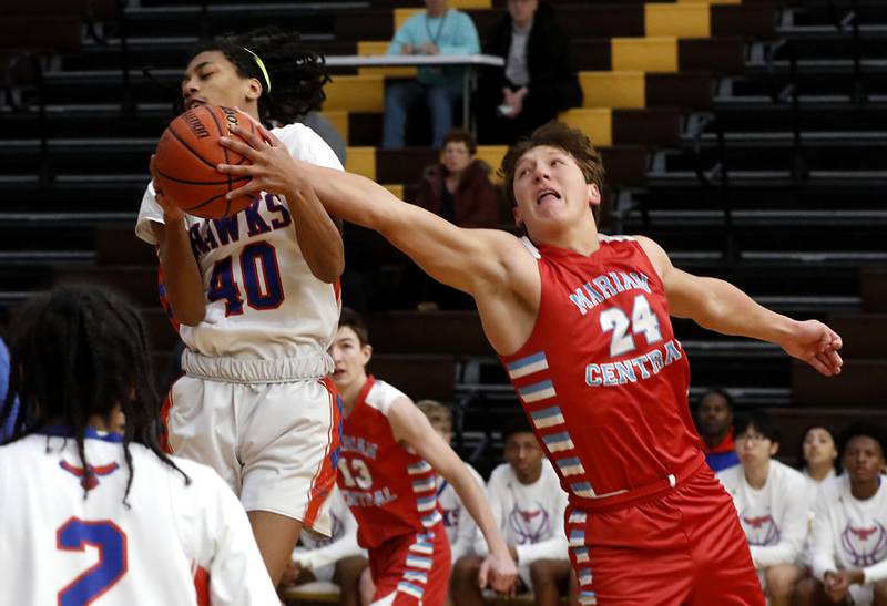 Marian Central's Christian Bentancur  (right) tries to grab a rebound against against Hoffman Estates’ D’marion Dunn during a Hinkle Holiday Classic basketball game Tuesday, Dec. 27, 2022, at Jacobs High School in Algonquin.