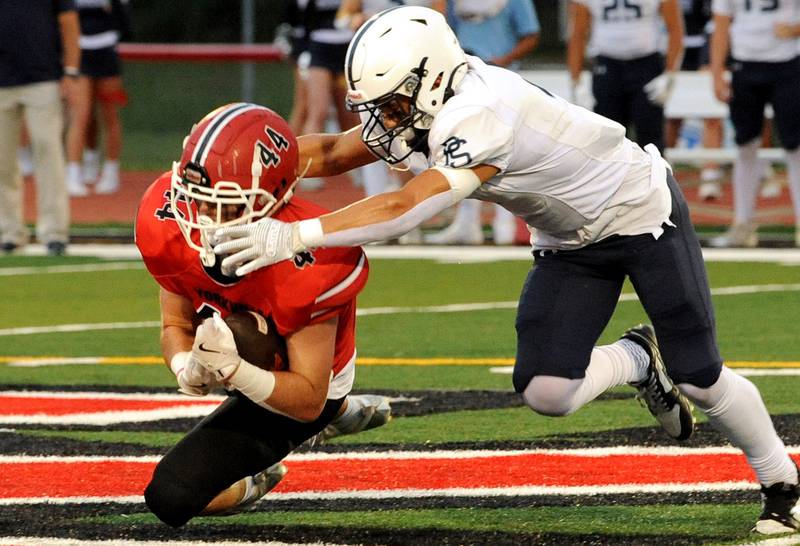 Yorkville running back Kenton Darnell (44) makes a diving catch against a Plainfield South defender on Friday, Sep. 30, 2024, at Yorkville High School.