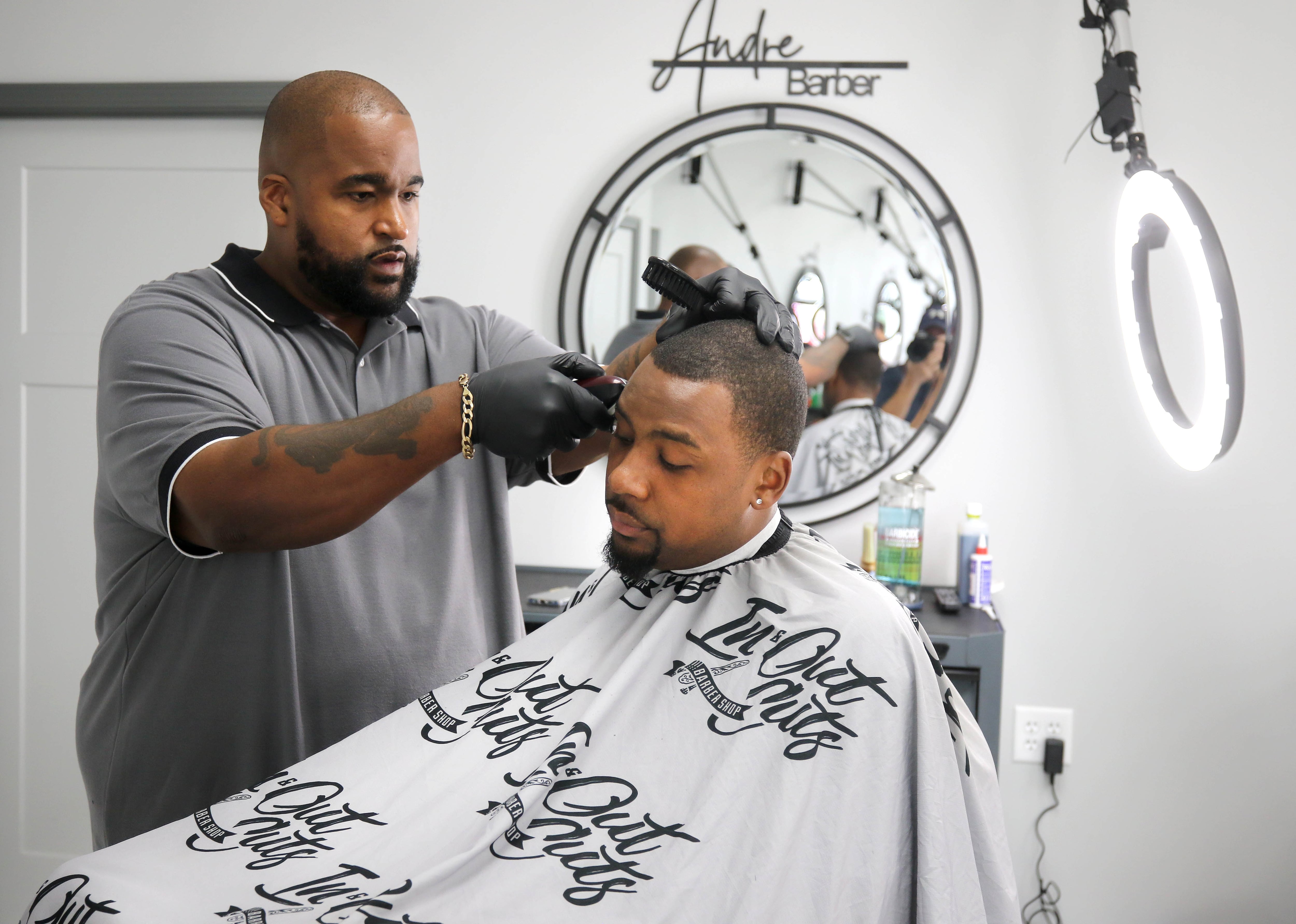 Julian McElroy gets a haircut from Andre Powell, owner of In & Out Cuts Barbershop, Friday, Aug 9, 2024, in the barbershop’s new location at 2331 Sycamore Road in DeKalb.