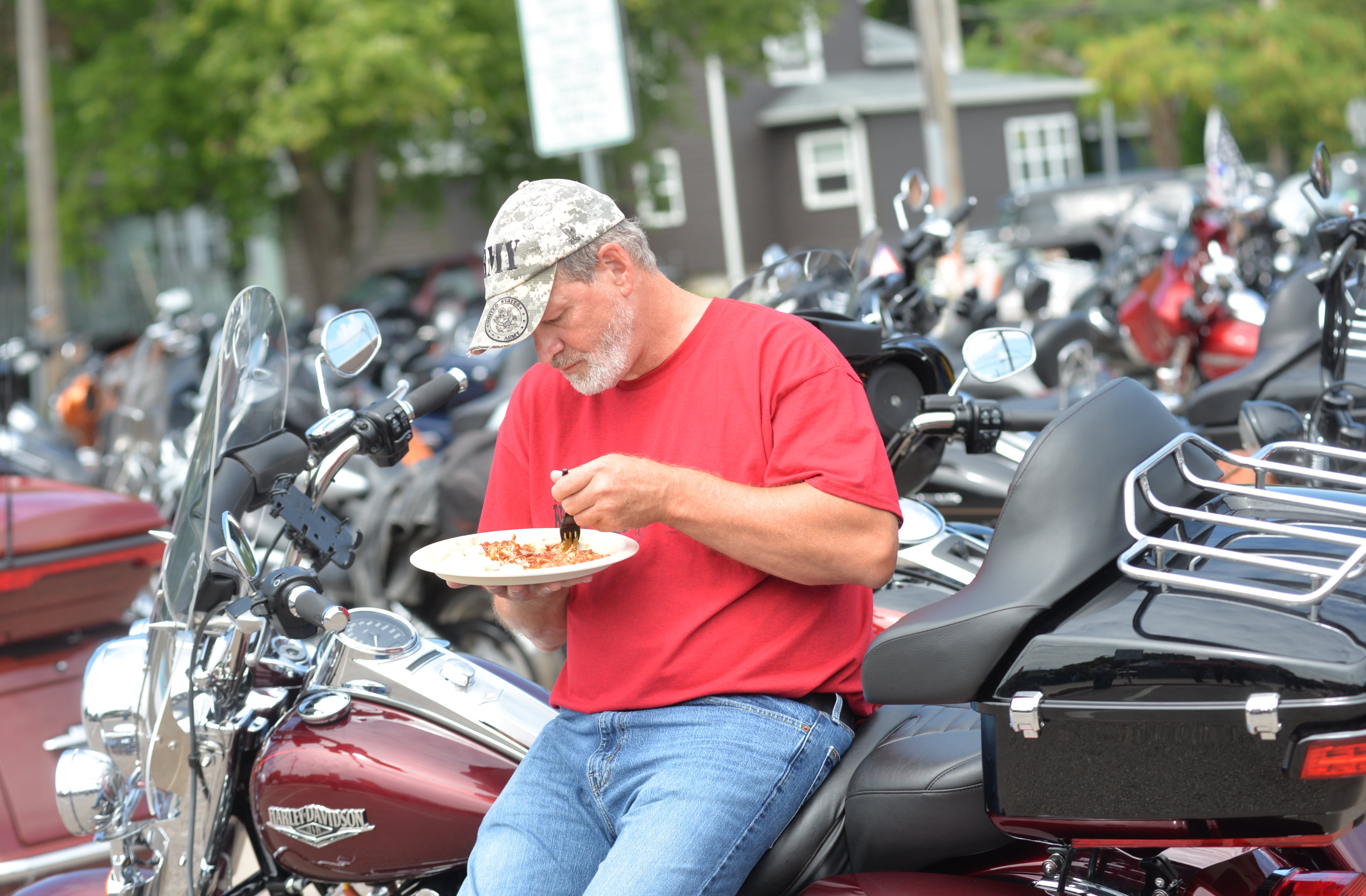 Dan Erdmann of Rockford eats his lunch while sitting on his Harley during the lunch stop at the Ogle County Brewery and Bad Ash Cigars during the Back the Blue Motorcycle Rally in Oregon on Saturday, Aug. 17, 2024.