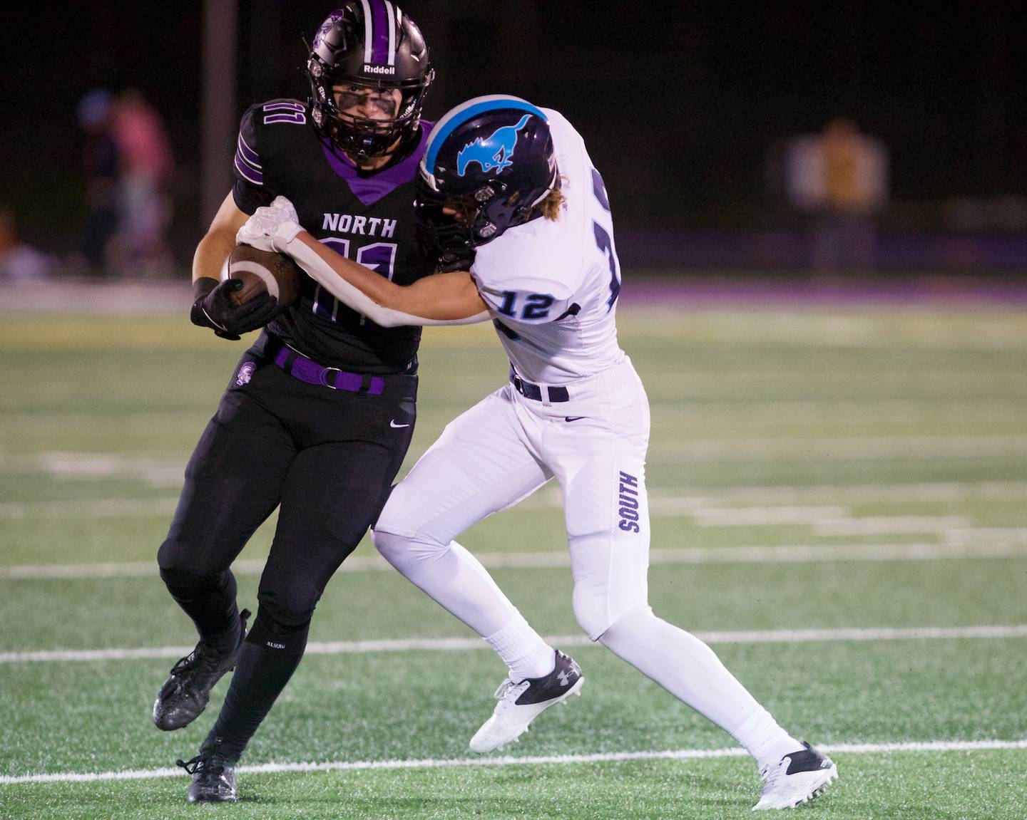 Downers Grove North's Charlie Cruse looks to carry the ball for a gain against Downers Grove South on Friday Sept. 6,2024 in Downers Grove.