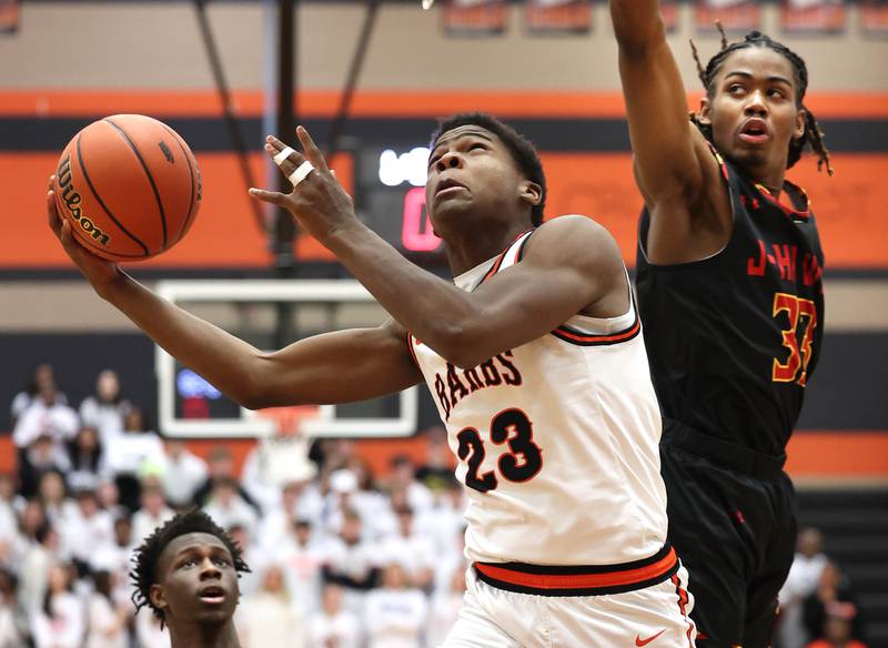 DeKalb’s Davon Grant goes under the basket for a layup in front of Jefferson's Cortez Christmas Wednesday, Feb. 21, 2024, during their Class 4A regional semifinal game at DeKalb High School.