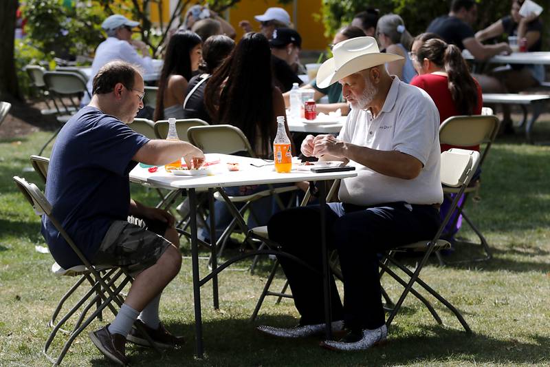 Peter Pozamoff and Steven DeMarco of Chicago enjoy steak and chorizo tacos during the annual Hispanic Connections Mexican Independence Day Celebration on Sunday, Sept. 15, 2024, in the Historic Woodstock Square. The celebration featured music, food and culture.