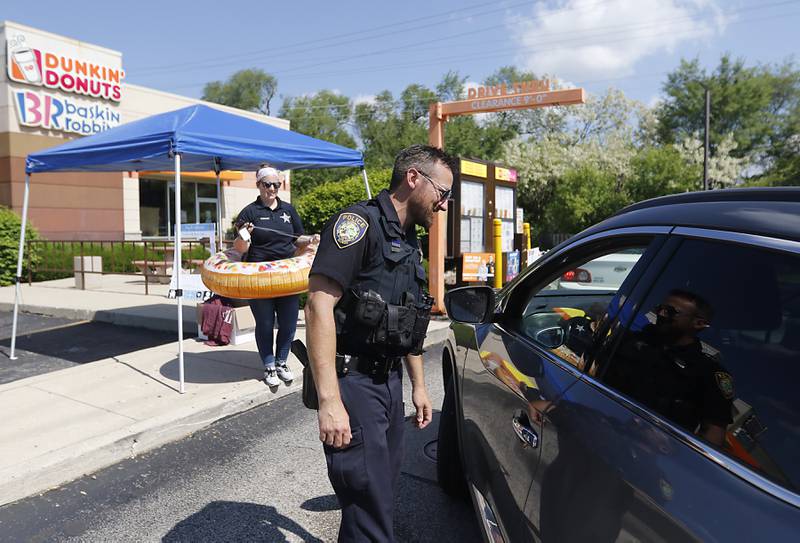 McHenry Police officer Robert Klasek talks with a customer during the Cop on a Rooftop fundraiser for Special Olympics Illinois on Friday, May 17, 2024, at the Dunkin’ Donuts at 4502 Elm Street in McHenry. Law enforcement officers spent their morning raising funds and awareness for Special Olympics Illinois and the Law Enforcement Torch Run.