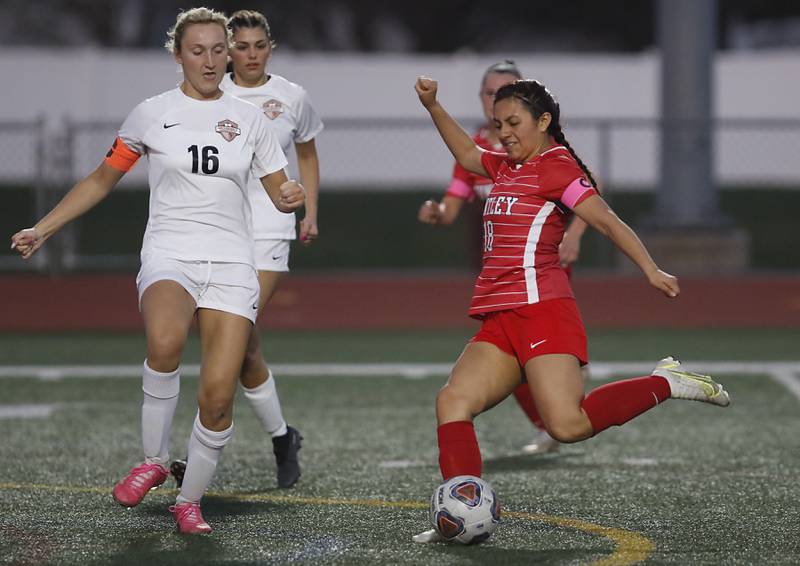 Huntley’s Karen Reyes-Villanueva takes a shot on goal as McHenry's Sarah Duginske defends during a Fox Valley Conference soccer match Thursday, April 13, 2023, at Huntley High School.