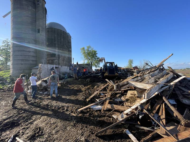 First responders and property owners tend the scene of a barn collapse along Weidner Road near Harvard on Tuesday evening.