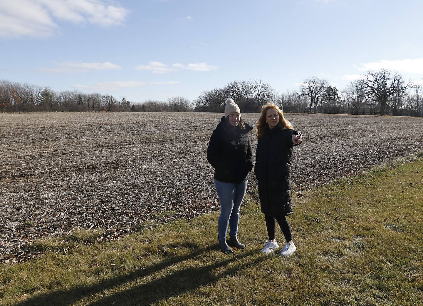 Megan Liebetrau and Kellie Bucci stand near a field that could become the proposed Riverwoods neighborhood on Thursday, Jan. 4, 2024. Many neighbors have opposed the housing development.