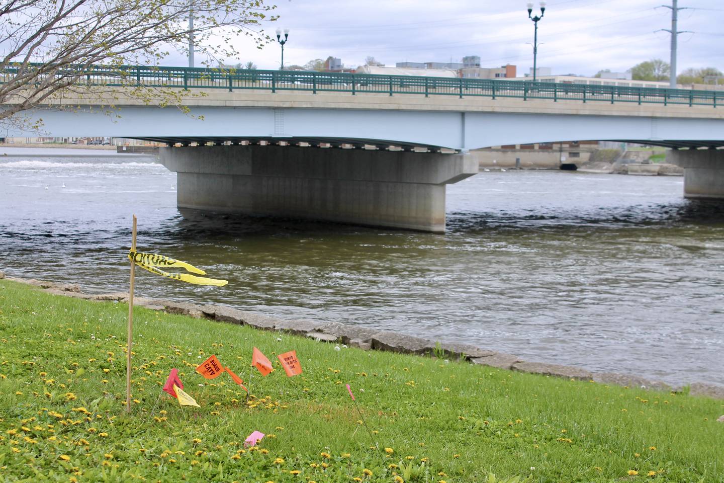 Utility flags mark a spot approximate to where a three-panel historical marker will be erected to the Truesdell Bridge Disaster of 1873 in Presidents Park in Dixon in a photo taken Monday, May 1, 2023. The marker will be dedicated in a ceremony Sunday. The 150th anniversary of the disaster is Thursday.