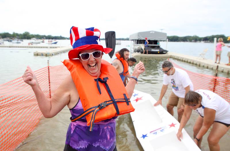 Bubba Campbell of Crystal Lake celebrates after dashing through the Cardboard Regatta in the kayak division on Crystal Lake Saturday.