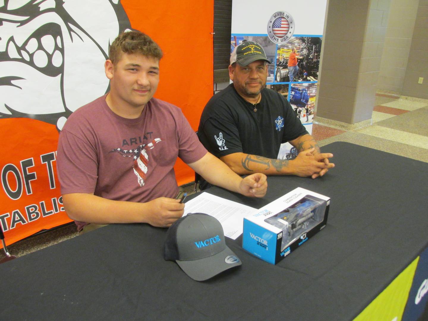 Streator High School student Carson Trenor accepts a full-time position at Vactor Manufacturing during a signing day event Thursday, May 11, 2023. He is with his father Terry Trenor, who also works at Vactor.