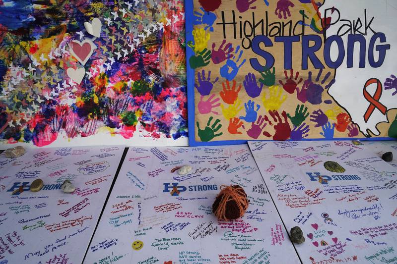 Hand-written, painted signs and rocks dedicated to the seven people killed and others injured in the Fourth of July mass shooting are seen at a memorial site, Thursday, July 21, 2022, in Highland Park.