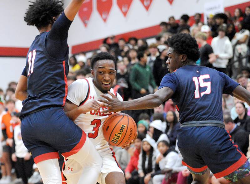 Yorkville's Dayvion Johnson (3) tries to split West Aurora defenders Jordan Brooks (11) and Kewon Marshall (15) during a class 4A regional semifinal basketball game at Yorkville High School on Wednesday, Feb. 21, 2024.