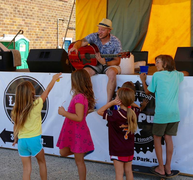 Todd Downing interacts with kids as he performs at the Maple Park Fun Fest on Saturday, Sept. 2, 2023.