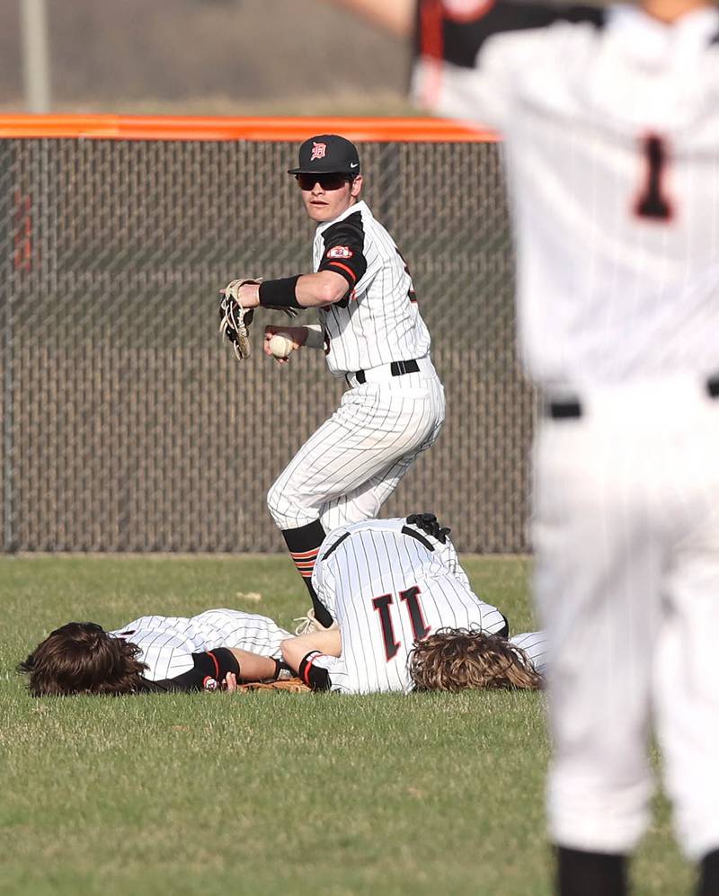 DeKalb's Nik Nelson gets the ball back in to the infield after Cole Latimer (left) and Landon Simonson collided while diving for a ball during their game against Metea Valley Thursday, April 13, 2023, at DeKalb High School. Both injured players were able to stay in to finish the inning.