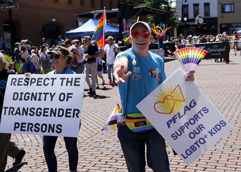 Jody Keck tosses candy as he walks with Parents Families and Friends of Lesbians and Gays during the Woodstock PrideFest Parade on Sunday, June 9, 2024, around the historic Woodstock Square.