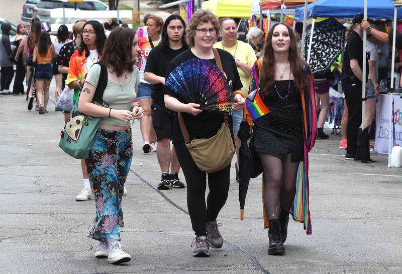 Many visitors used colorful fans to keep cool as they visited the tents Thursday, June 20, 2024, in front of the Egyptian Theatre during DeKalb Pride Fest.