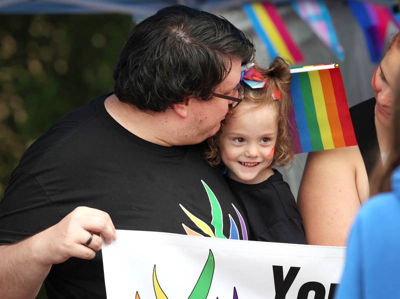 Chad Bishop gives his daughter Arabella, 4, a kiss at the Sycamore United Methodist Church tent in Van Buer Plaza in front of the Egyptian Theatre Thursday, June 20, 2024, during DeKalb Pride Fest.