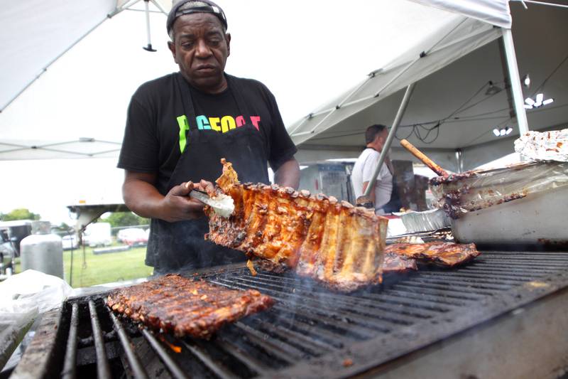 Frank Gary heats ribs at the Pigfoot booth during the Rockin’ Rib Fest Friday at Sunset Park in Lake in the Hills.