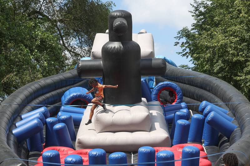 A child plays on the large inflatable obstacle course at the Healing the Hood event held at the St. Mark CME Church in Joliet on Saturday June 29, 2024.