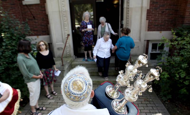 People file out of the building a final time as the McHenry County Jewish Congregation held a deconsecration ceremony at their Ridgefield Road location in preparation for a move to the Tree of Life Unitarian Church in McHenry on Sunday, August 18. Mezuzot were removed from doorways and the Torah Scrolls were removed from their ark and transported  to the new building as worshipers consecrated the new building as their synagogue.