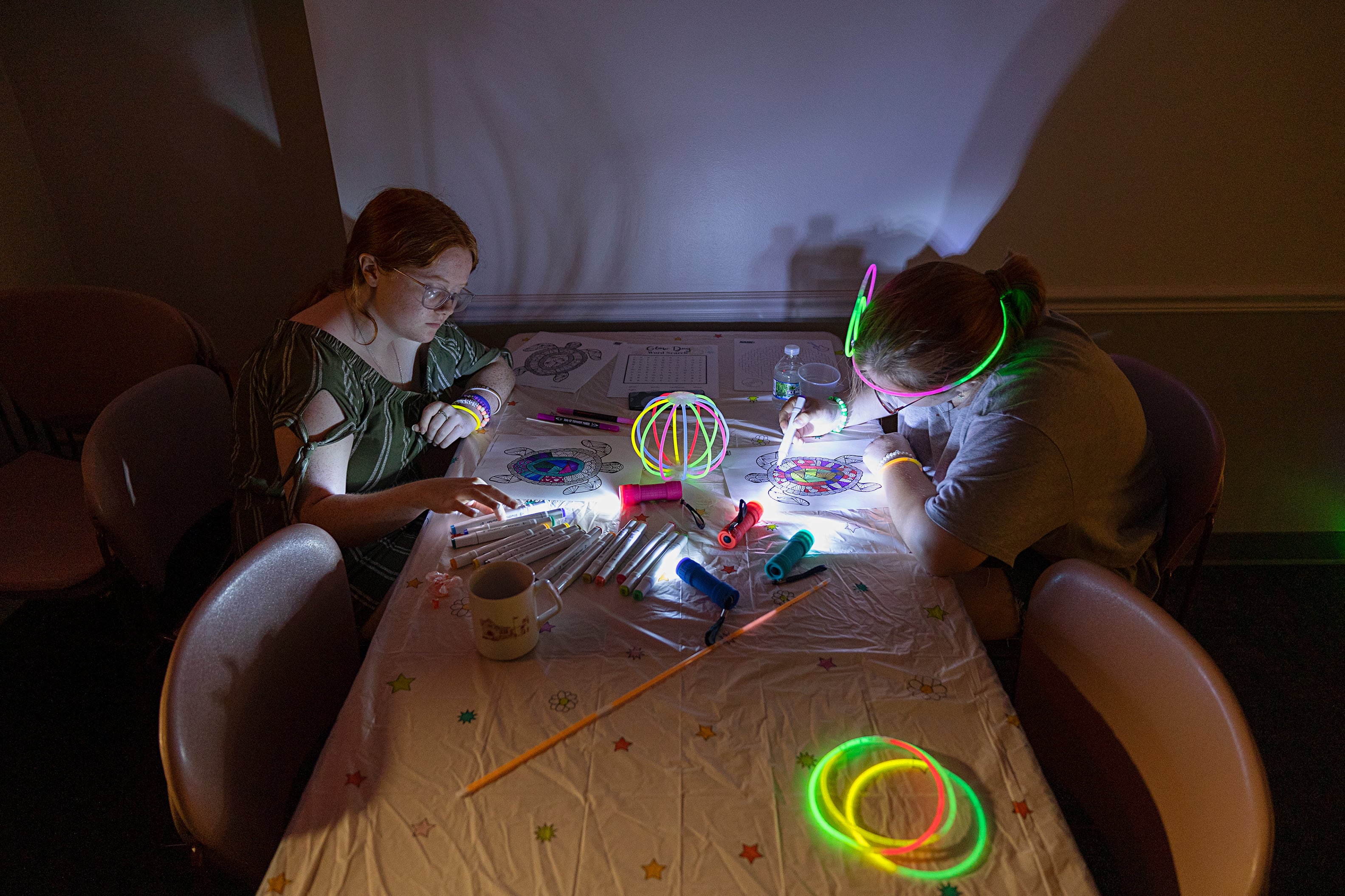 Lillyanna (left), 15, and Annalise Tranbarger 13, work on an art piece Tuesday, July 16, 2024, at the Dixon Public Library. Young adult librarian Brianna Doyle organized the glow party to bring in teens to the library. Doyle will host a program about once a quarter moving forward.