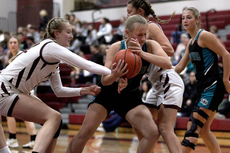 Marengo’s Gabby Gieseke, right, and Dayna Carr, left, pressure Woodstock North’s Caylin Stevens in varsity girls basketball at Marengo Tuesday evening.