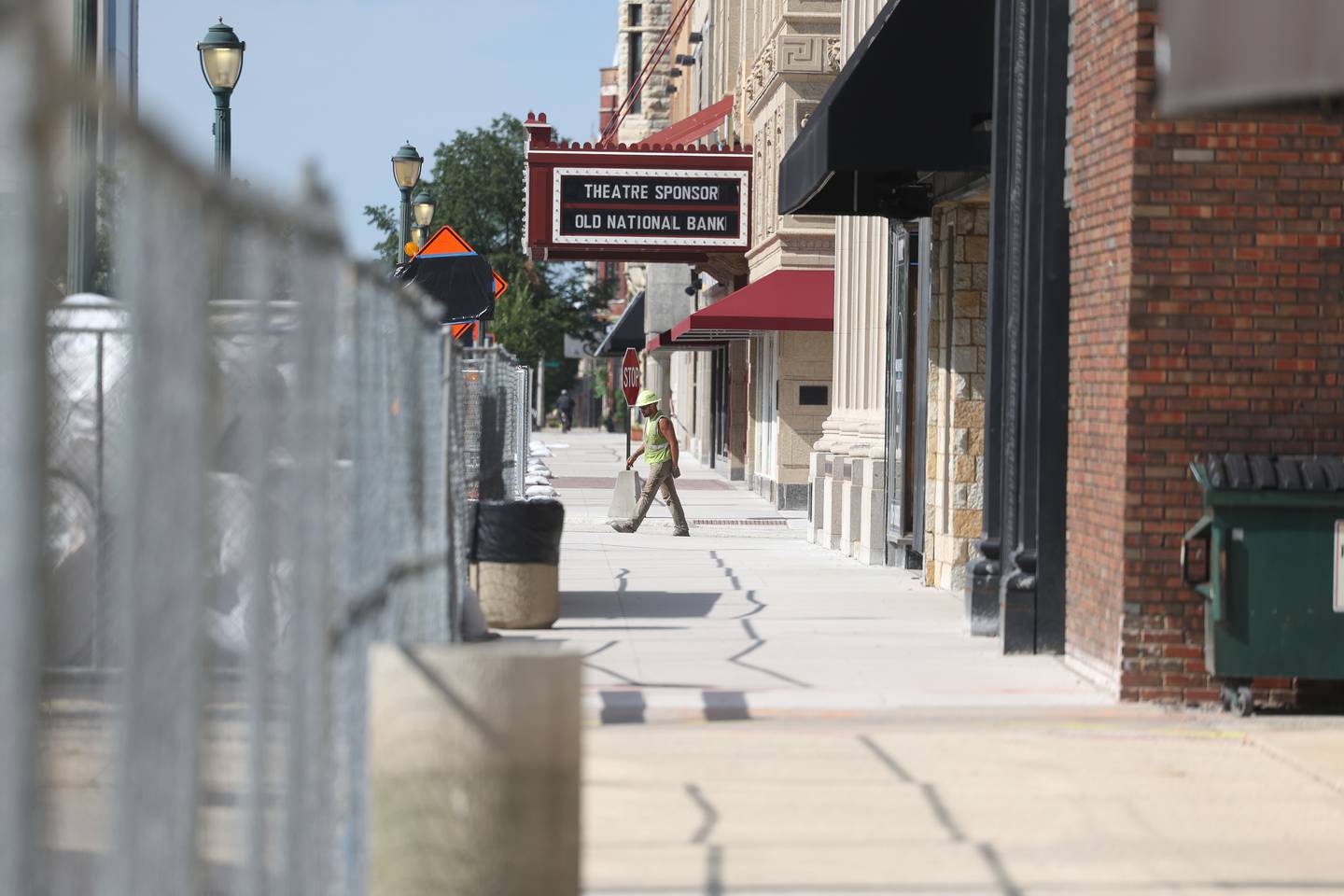 A construction worker crosses the street along North Chicago Street as phase one to improve water and sewer line begins for the new City Square in downtown Joliet on Wednesday, Aug. 7, 2024.