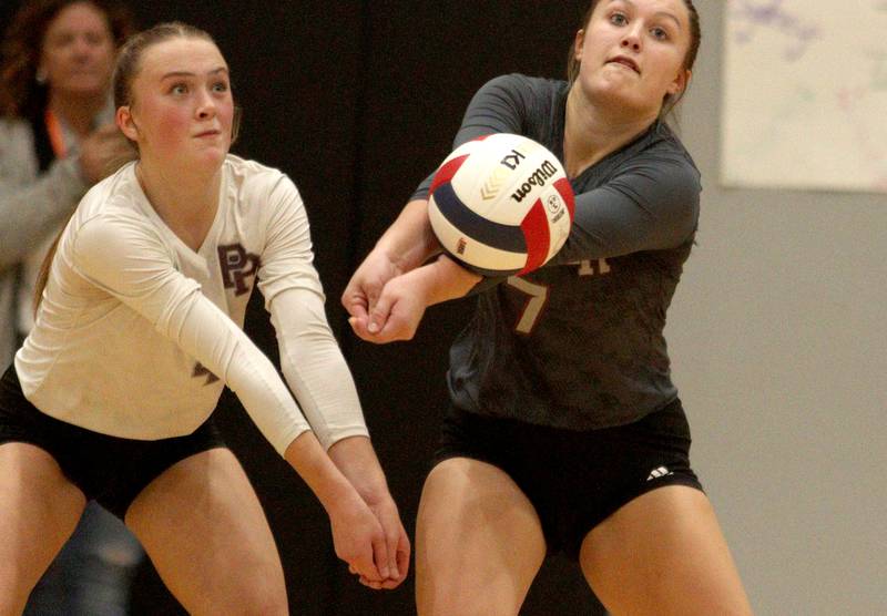 Prairie Ridge’s Addison Gertz, right, passes the ball against Woodstock in IHSA Class 3A sectional semifinal volleyball action at Woodstock North Monday. At left is Alli Rogers.