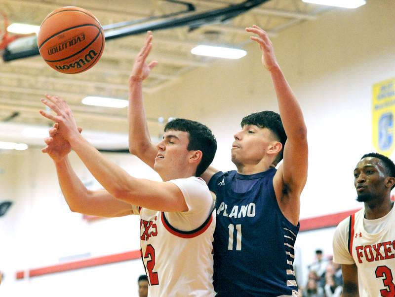 Yorkville's Will Eberhart (12) get bumped for a foul by Plano defender Eric Cano (11)  during a varsity basketball game at Yorkville High School on Tuesday, Dec. 19, 2023.