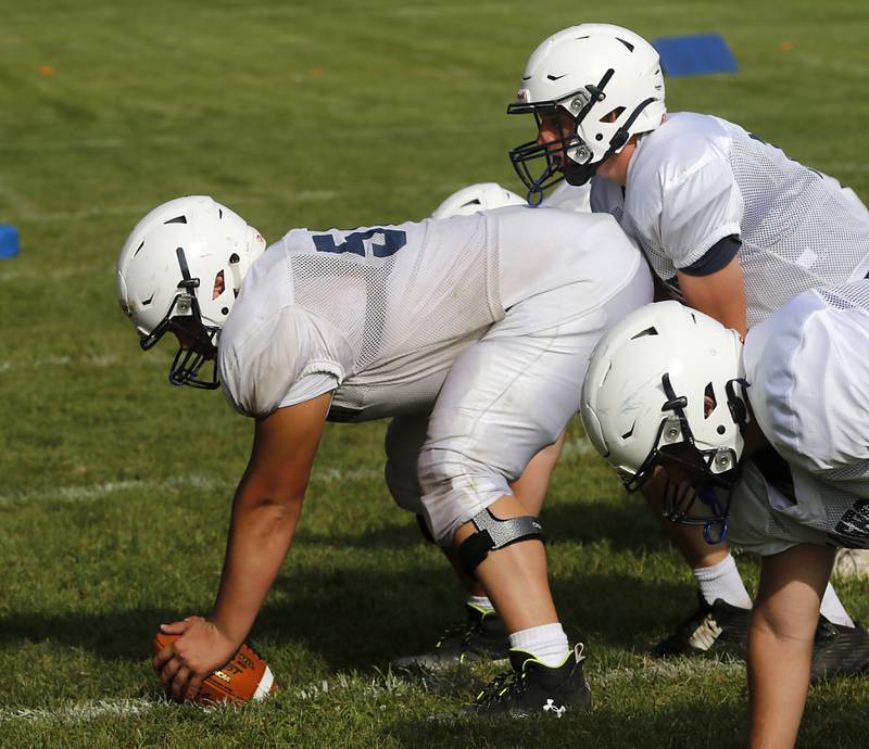 Center Lucas Burton snaps the ball to quarterback Peyton Seaburg during football practice Tuesday, Aug. 20, 2024, at Cary-Grove High School, as the 2023 IHSA Class 6A champions look to defend their title.