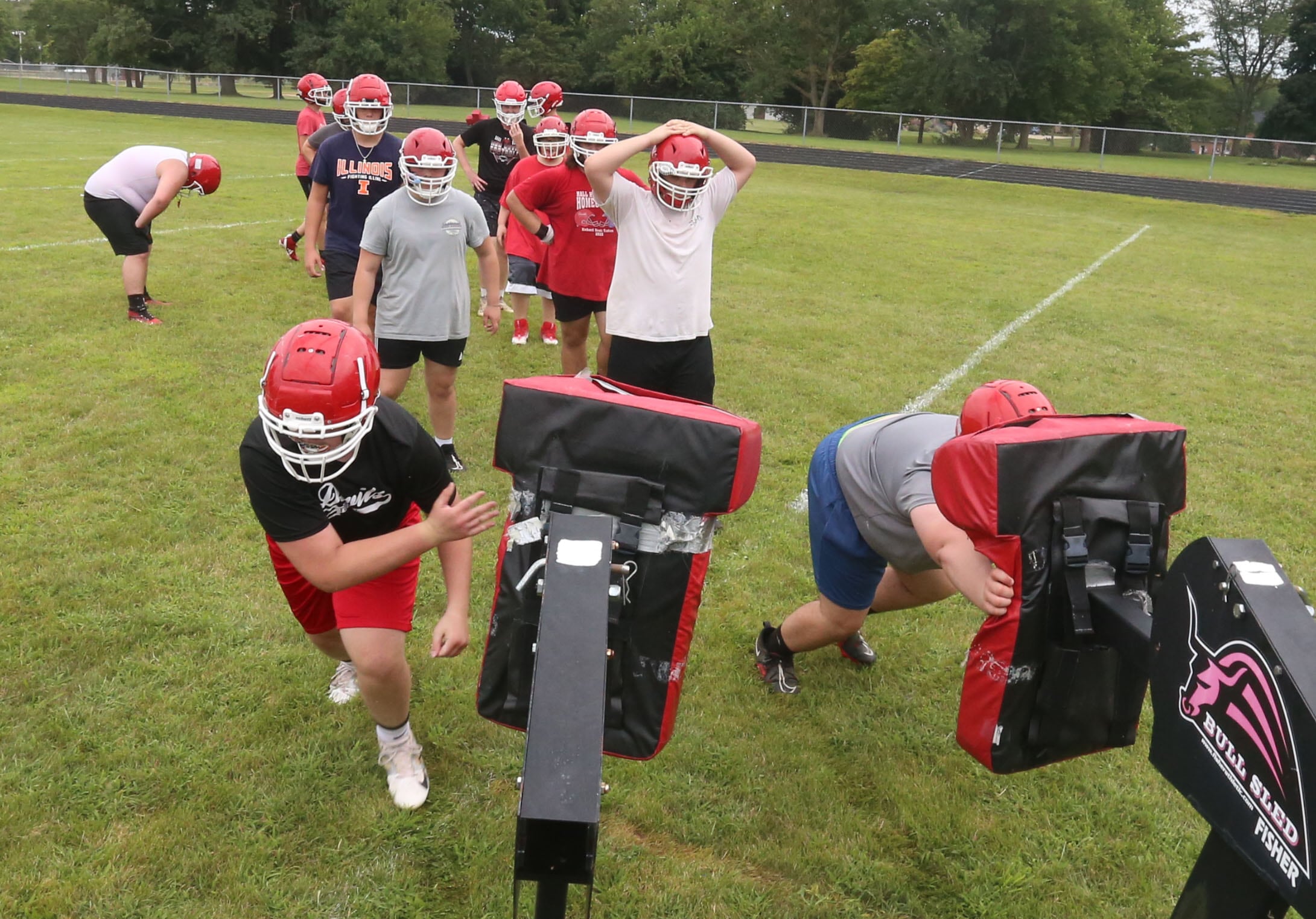 Members of the Hall football team run sled drills during the first day of practice on Monday, Aug. 12, 2024 at Hall High School.