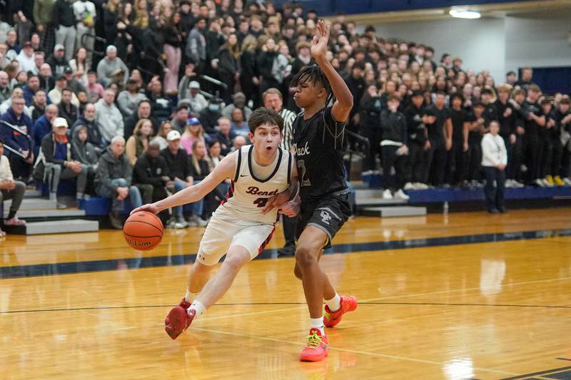 Benet’s Patrick Walsh (4) drives to the basket against Oswego East's Mason Lockett IV (2) during a Class 4A Oswego East regional final basketball game at Oswego East High School on Friday, Feb 23, 2024.