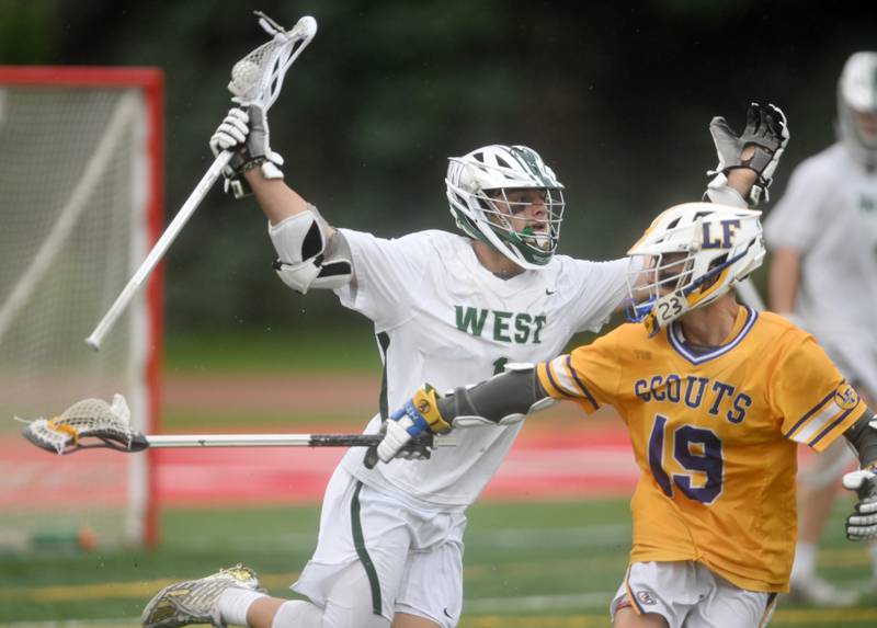 Glenbard West’s Ben Cesario, left, moves past Lake Forest’s Emmet Lee during the boys lacrosse state title game on Saturday, June 1, 2024 in Hinsdale. Lake Forest won 4-1.