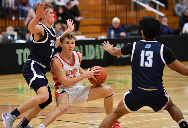 Batavia's Nate Nazos is double teamed by Downers Grove South's Will Potter and Richard Gasmen (13) during a Jack Tosh Classic game on Dec. 26, 2023 at York High School in Elmhurst.