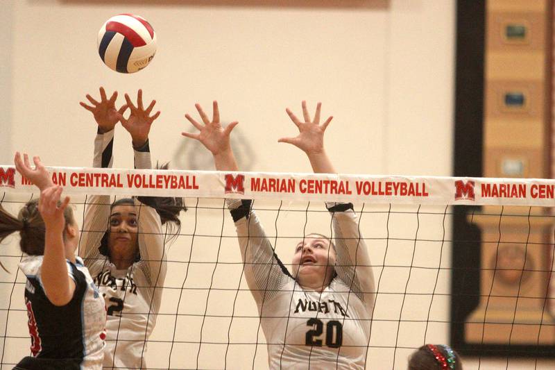 Grayslake North’s Chanea Butler, left, and Emily Owen block in girls volleyball at Marian Central in Woodstock Monday.