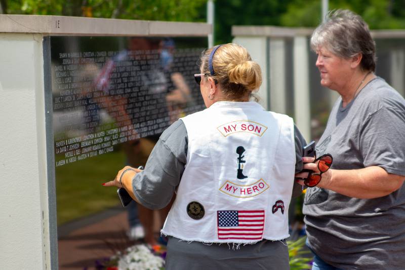 A Gold Star family mourns while reading his name on the Middle East Conflicts Wall Memorial on Saturday, June 15, 2024, during the Illinois Motorcycle Freedom Run in Marseilles.