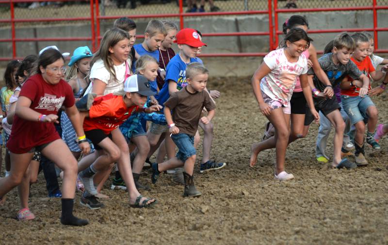 Kids rush to find one of their shoes during entertainment at the Big Hat Rodeo during the Ogle County Fair on Friday, Aug. 4, 2023.