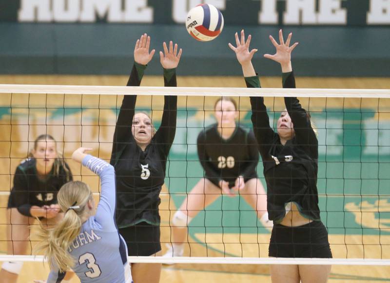 Bureau Valley's Taylor Neuhalfen puts a kill between St. Bede's Emma Smudzinski and teammate Ashlyn Ehm