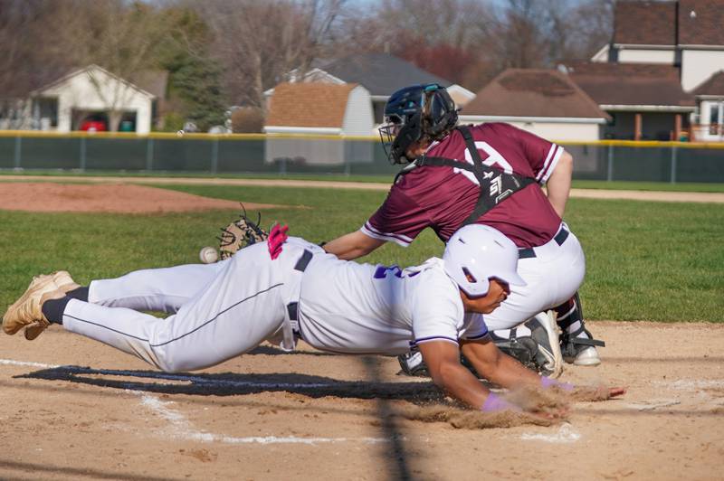 Plano's Jason Phillips (42) slides into home beating the throw to the plate for a score during a baseball game against Marengo at Plano High School on Monday, April 8, 2024.