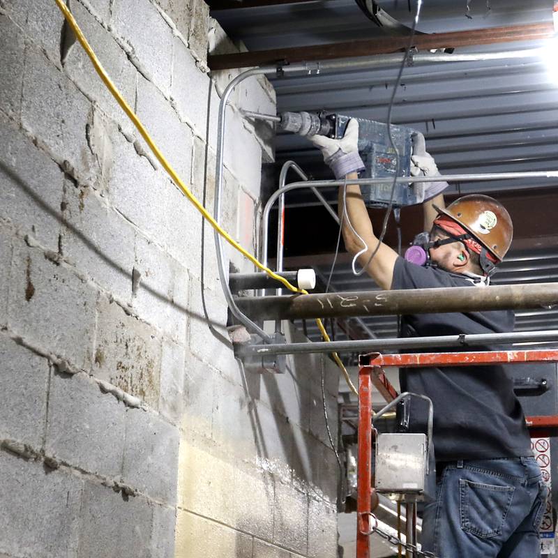 A construction worker removes a piece of a wall Tuesday, Feb. 7, 2023, at the old Cary Village Hall, at 655 Village Hall Drive in Cary. Work has started on converting the space into the McHenry County Sheriff's Office's new law enforcement training facility. The facility will allow local agencies to train closer to home.