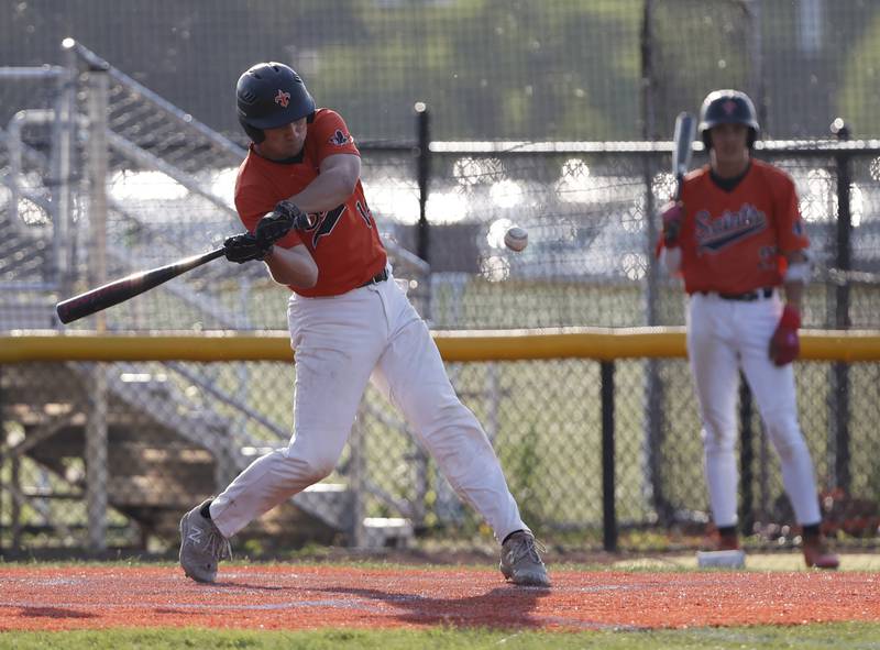 St. Charles East's Mac Paul (14) makes contact during the Class 4A York regional semi-final between Wheaton Warrenville South and St. Charles East in Elmhurst on Thursday, May 23, 2024.
