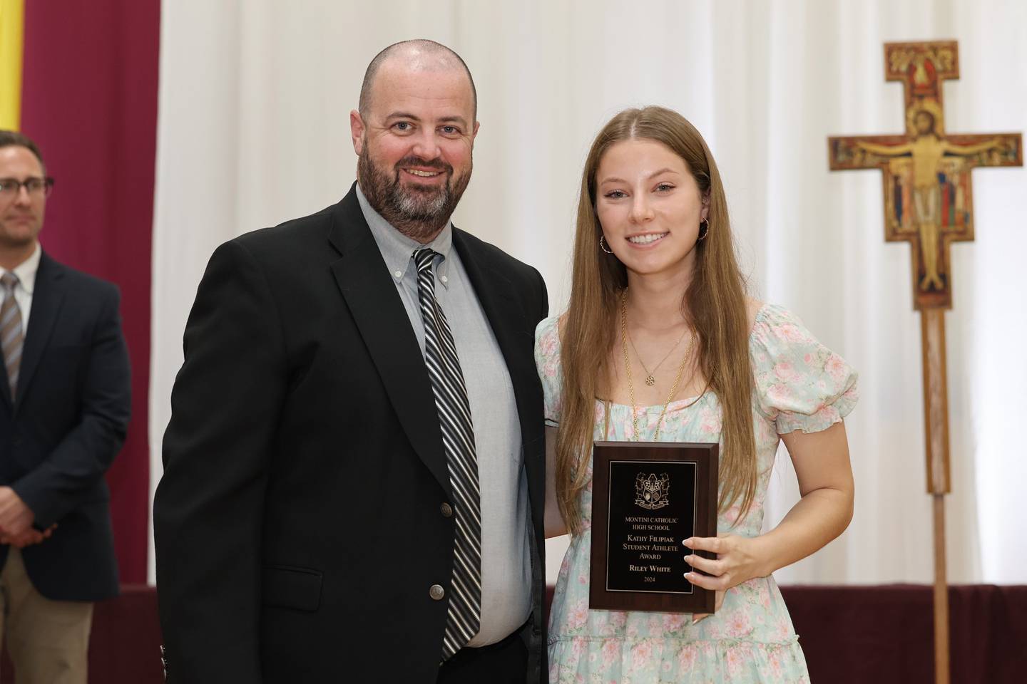 Montini Catholic High School senior Riley White receives the Kathy Filipiak Scholar/Athlete Award from Athletic Director Brian Casey at the school's Founders Day ceremony on May 17, 2024