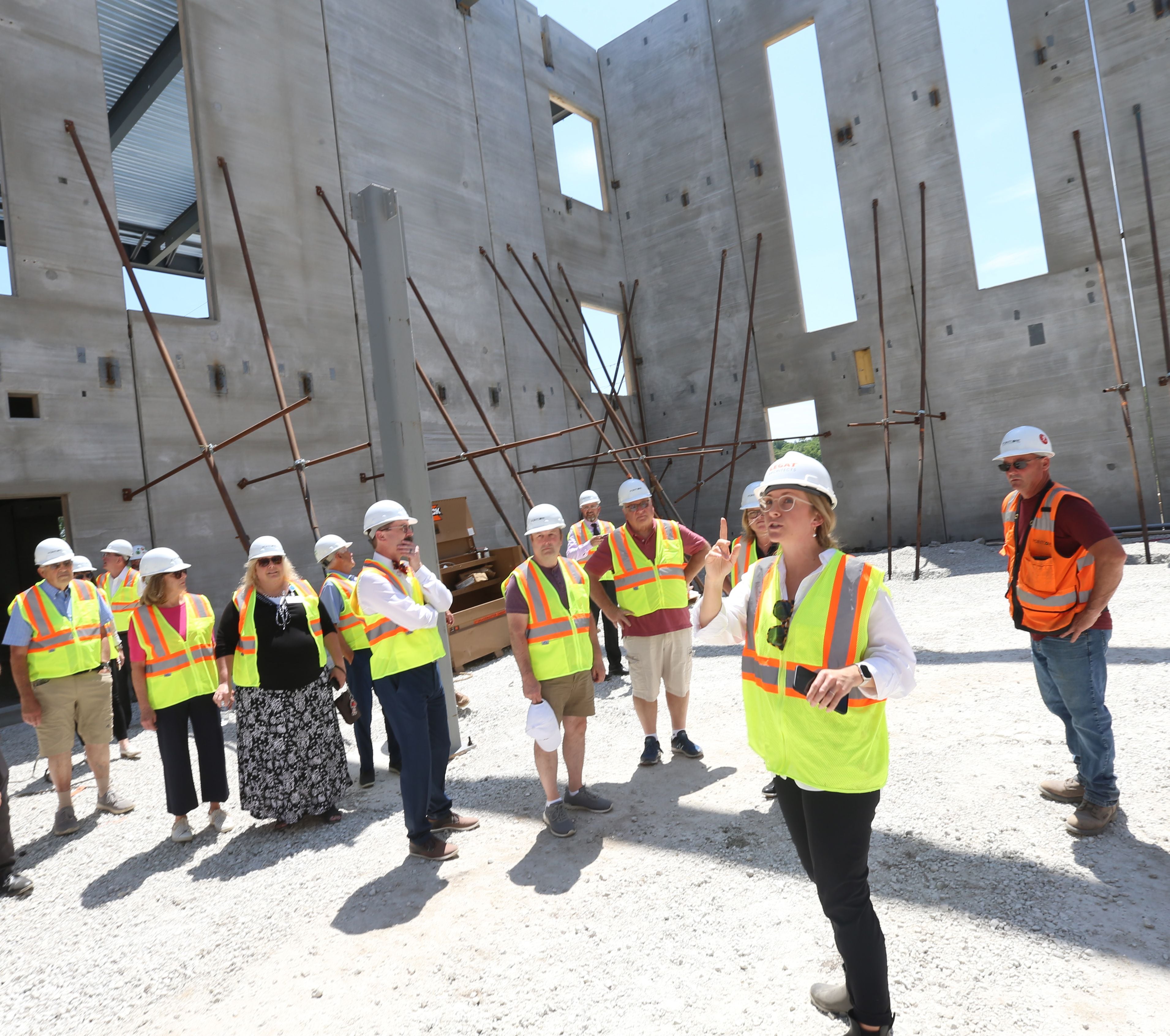 Audrey Riggs, project associate, and Joe Gilliam, project superintendent, give a guided tour during a steel signing celebration on Tuesday, May 30, 2023, at the new YMCA building site in Ottawa.