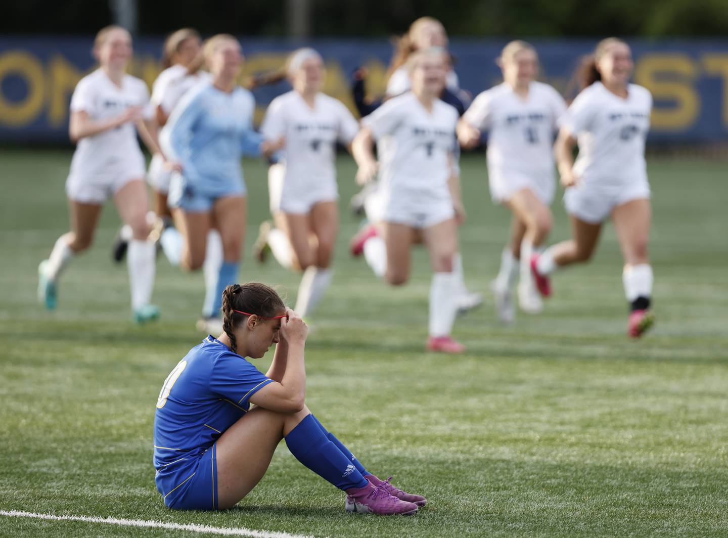 Lyons' Caroline McKenna (10) sits in disbelief as New Trier celebrates winning the Class 3A Dominican super-sectional between New Trier and Lyons Township in River Forest on Tuesday, May 28, 2024.