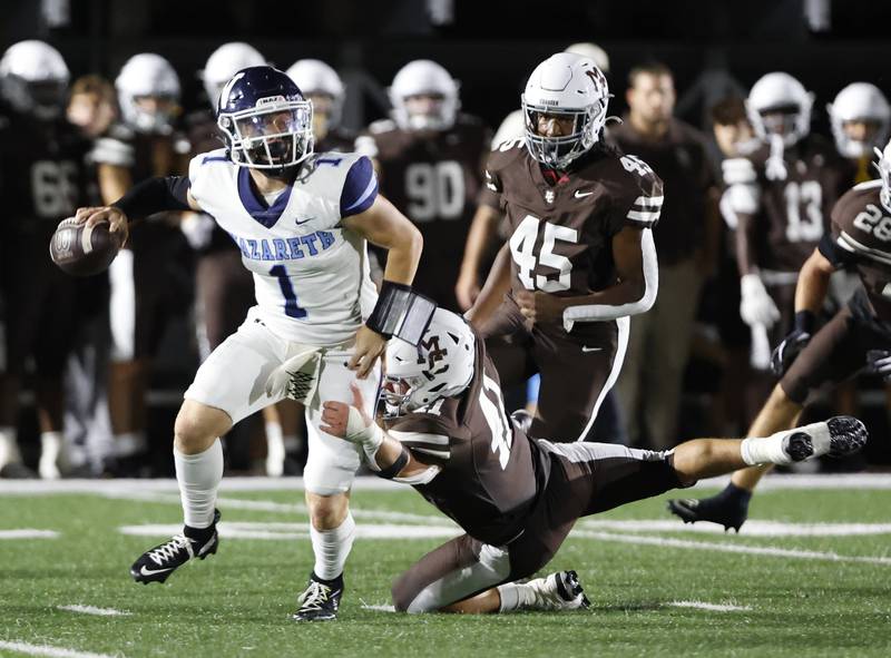 Nazareth's Logan Malachuk (1) passes the ball as Mt. Carmel's Matthew Mucha (41) closes in during the varsity football game between Nazareth Academy and Mt. Carmel high school on Friday, Sep. 13, 2024 in Chicago.