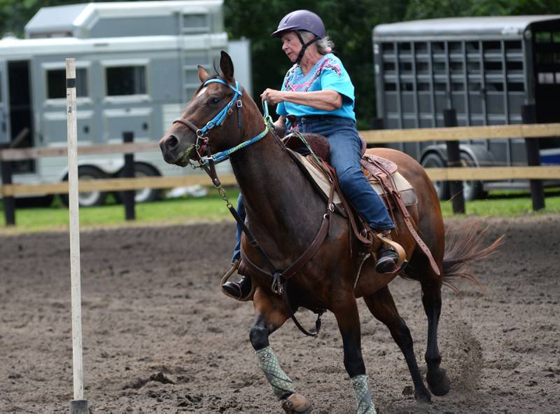 Ellen Inman, 75, of Davis Junction navigates her horse, Heather, 6,  through the Poles Competition at the Rock River Trail & Horseman Association's Grand Opening Show on Saturday, July 20, 2024. Inman started competing in barrel racing when she was 60 after driving  her daughters and granddaughters to their competitions.