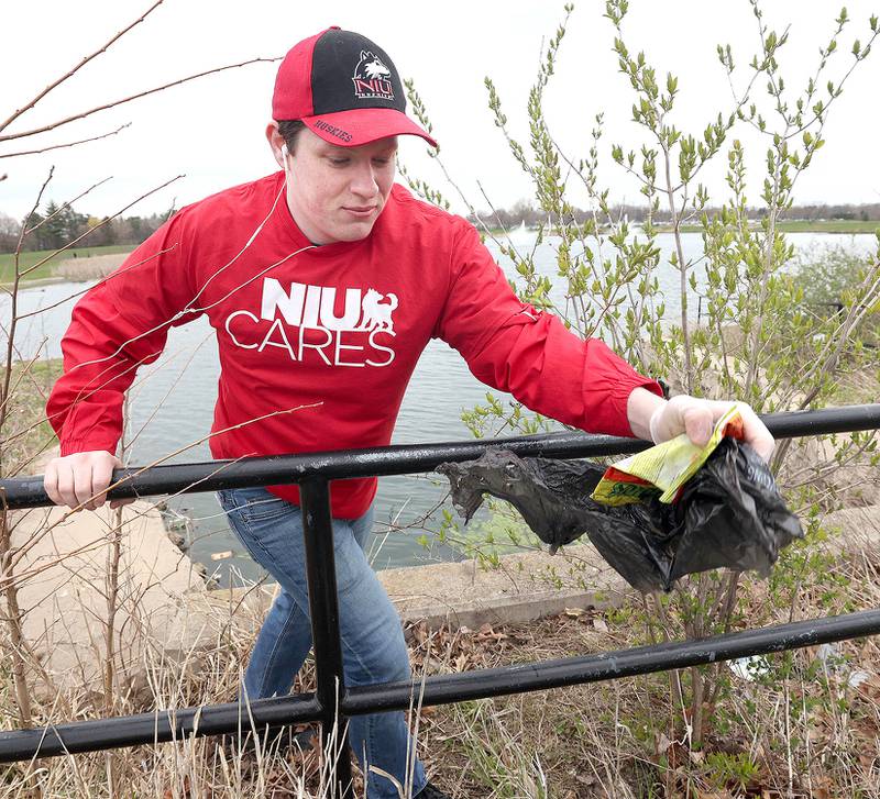 Matthew Outzen, a Northern Illinois University senior from Fulton and a member of NIU Cares, picks up garbage Friday, April 29, 2022, on campus around the West Lagoon. NIU Cares, with the help of the Trash Squirrels, was taking part in a community cleanup event, going to several locations in DeKalb to pick up litter.